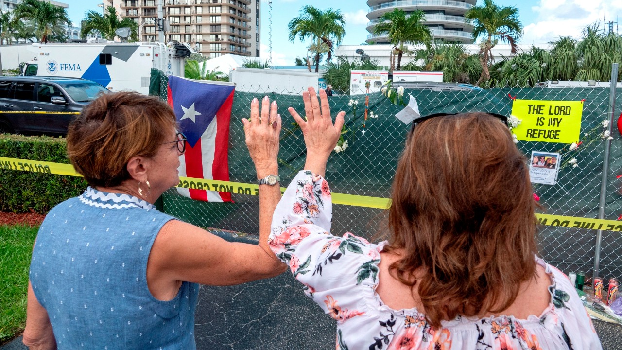 Familiares de desaparecidos de derrumbe en Miami rezan y lloran en los escombros