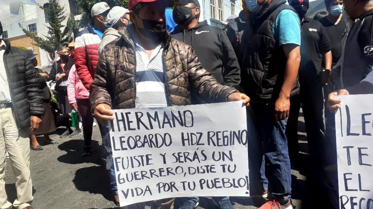 Familiares y amigos del joven Leobardo Hernández Regino portan cartulinas tras su muerte.