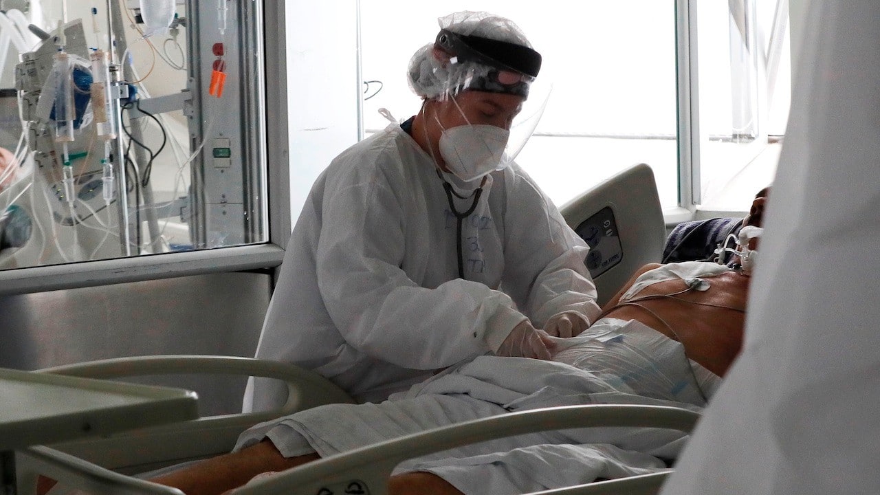 Una empleada de la salud atiende a un paciente en una unidad de cuidados intensivos en Bogotá, Colombia (EFE)