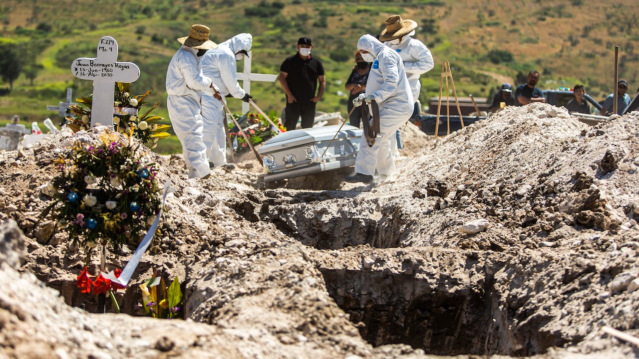 Los trabajadores de un cementerio en Tijuana, México llevan el cuerpo de una víctima de COVID-19 (Getty Images)