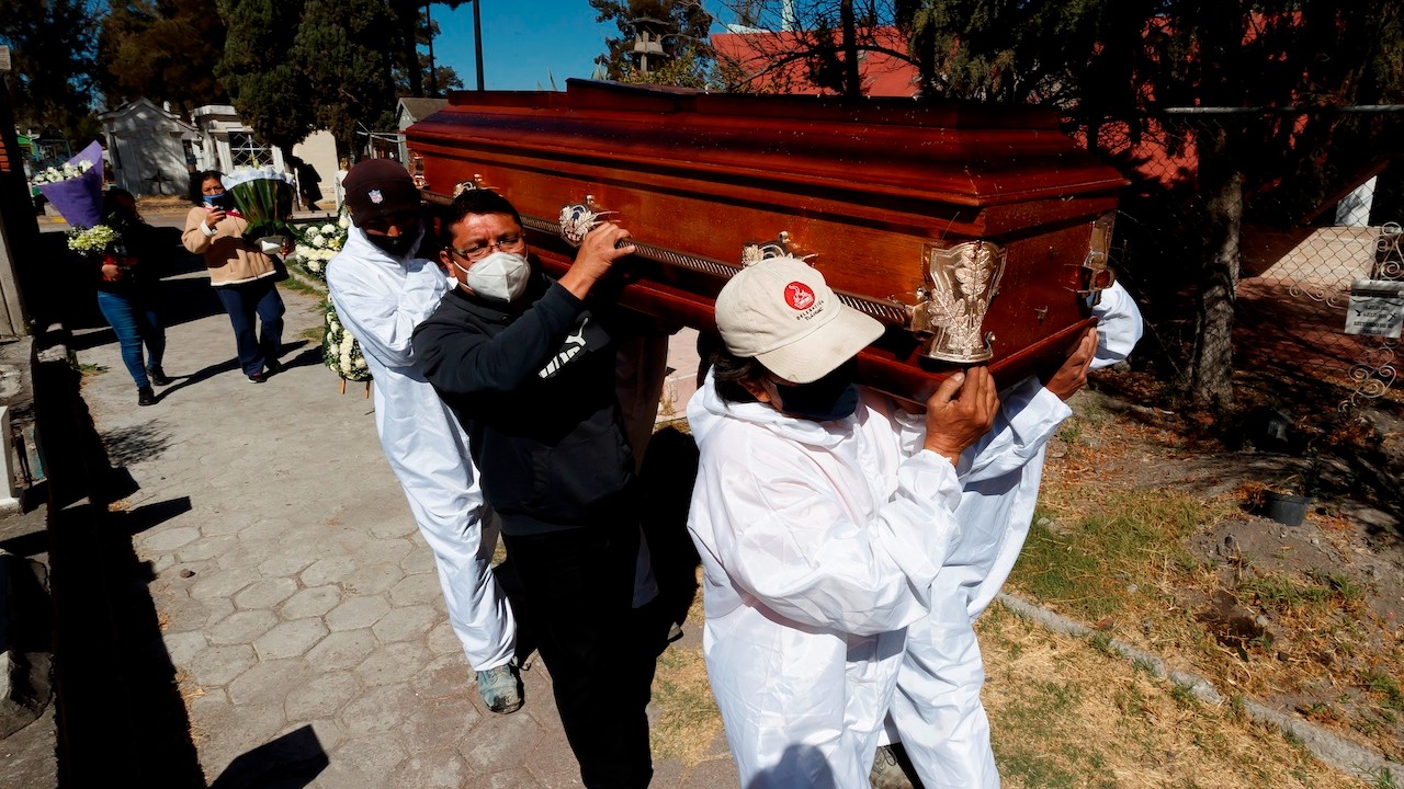 Familiares asisten al entierro de un fallecido por COVID-19 en el Panteón de Tláhuac, en CDMX (EFE)