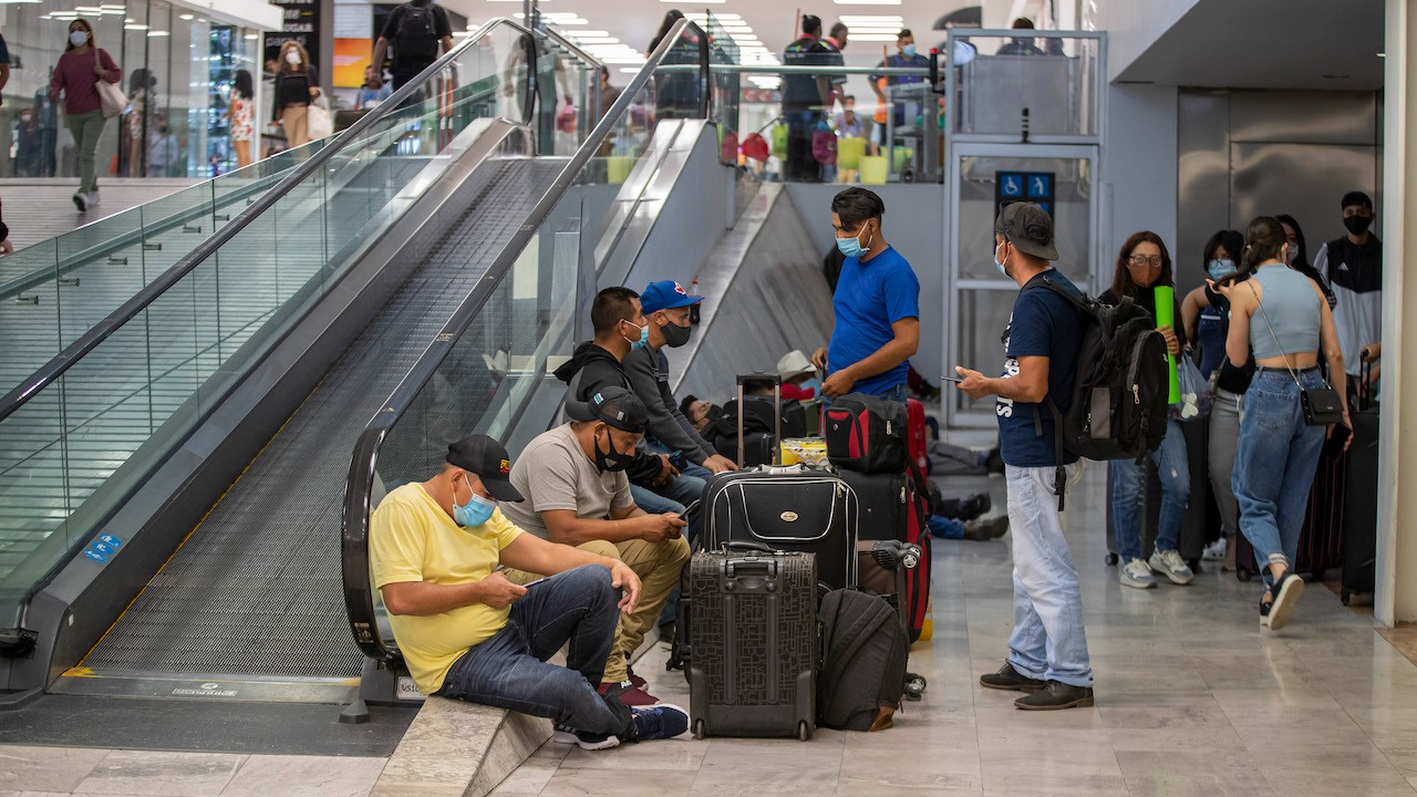 Pasajeros descansan mientras esperan sus vuelos en el Aeropuerto Internacional de la Ciudad de México (Getty Images)