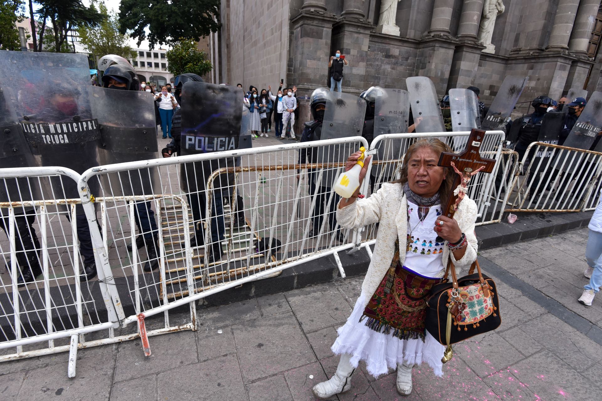 Mujer con cruz arrojó agua bendita a feministas en Toluca