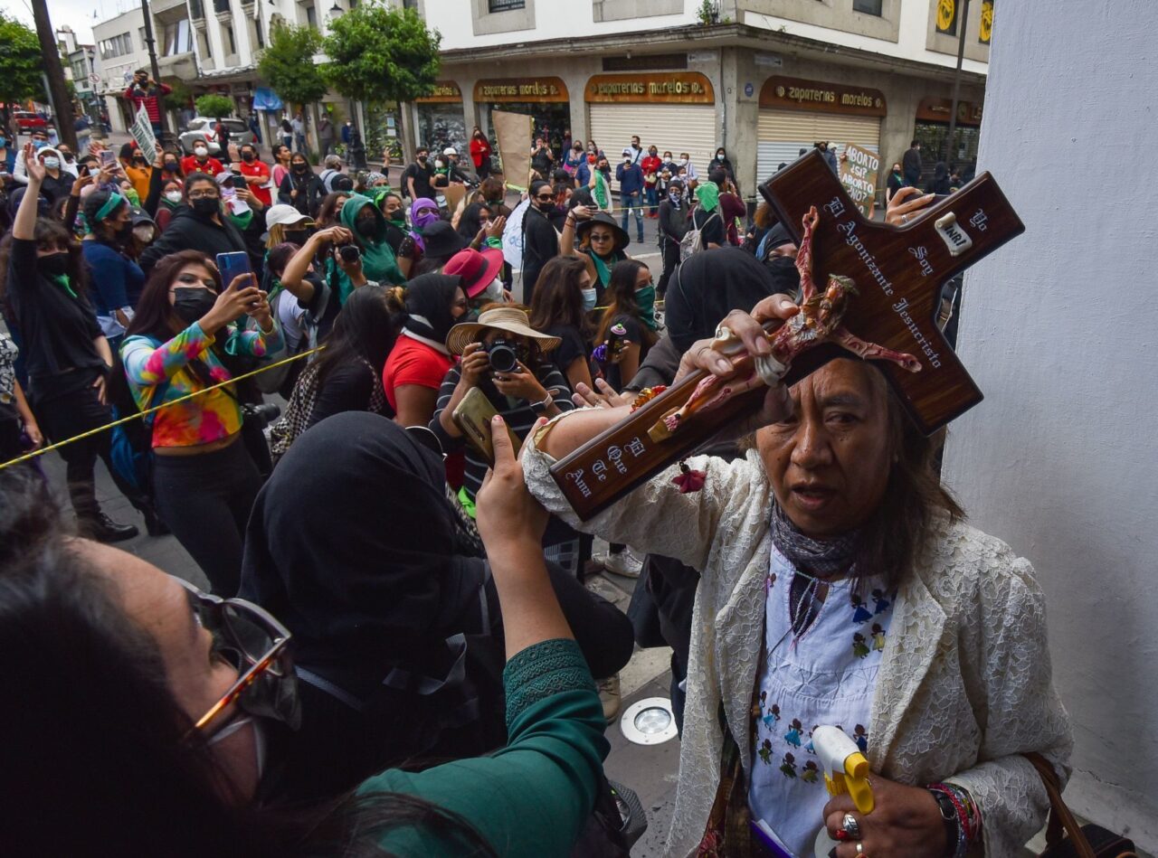 Mujer con cruz arrojó agua bendita a feministas en Toluca