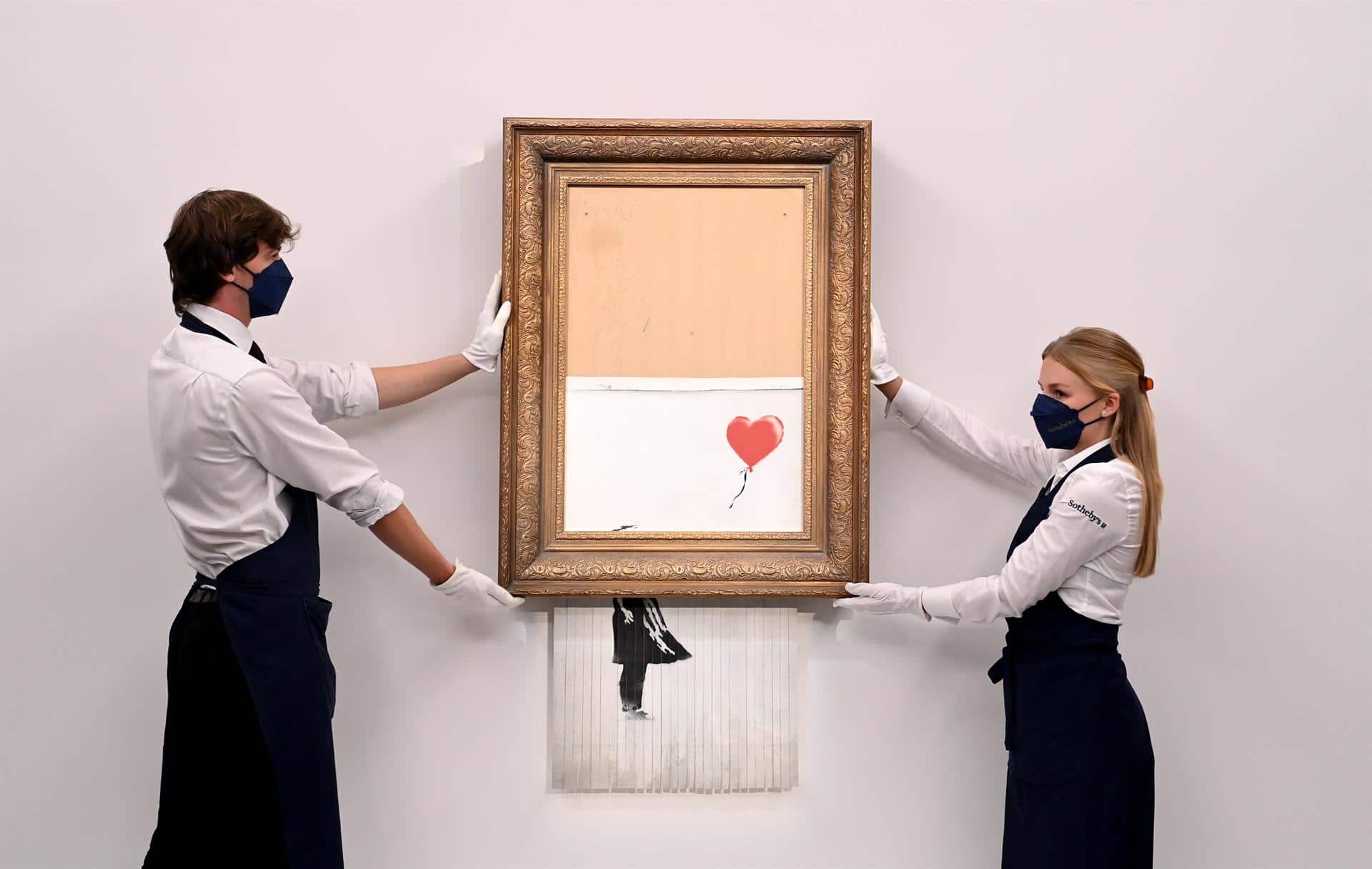 Pintura titulada 'Love is in the Bin' del artista callejero británico anónimo Banksy en la casa de subastas Sotheby's en Londres (EFE)
