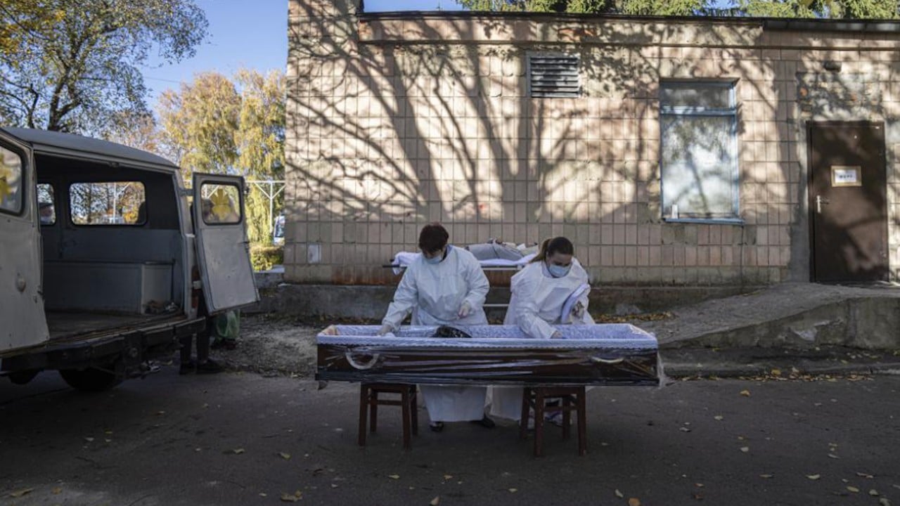 Personal médico prepara un ataúd para un paciente que murió de coronavirus en Ucrania (AP)