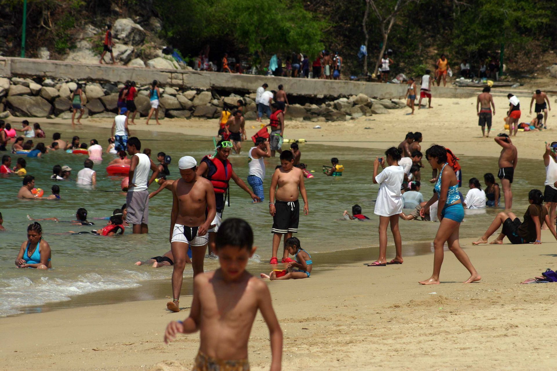 Turistas disfrutando de las playas de Huatulco, Oaxaca.