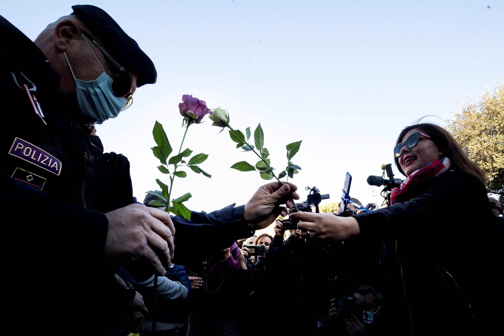 Una mujer ofrece una rosa a un policía durante una manifestación de protesta por el certificado covid (EFE)