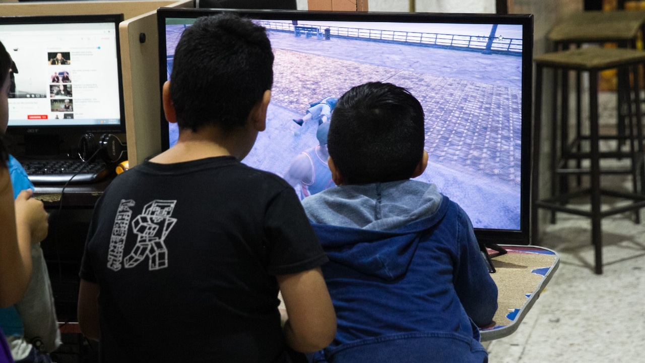 Niños juegan videojuegos en el mercado