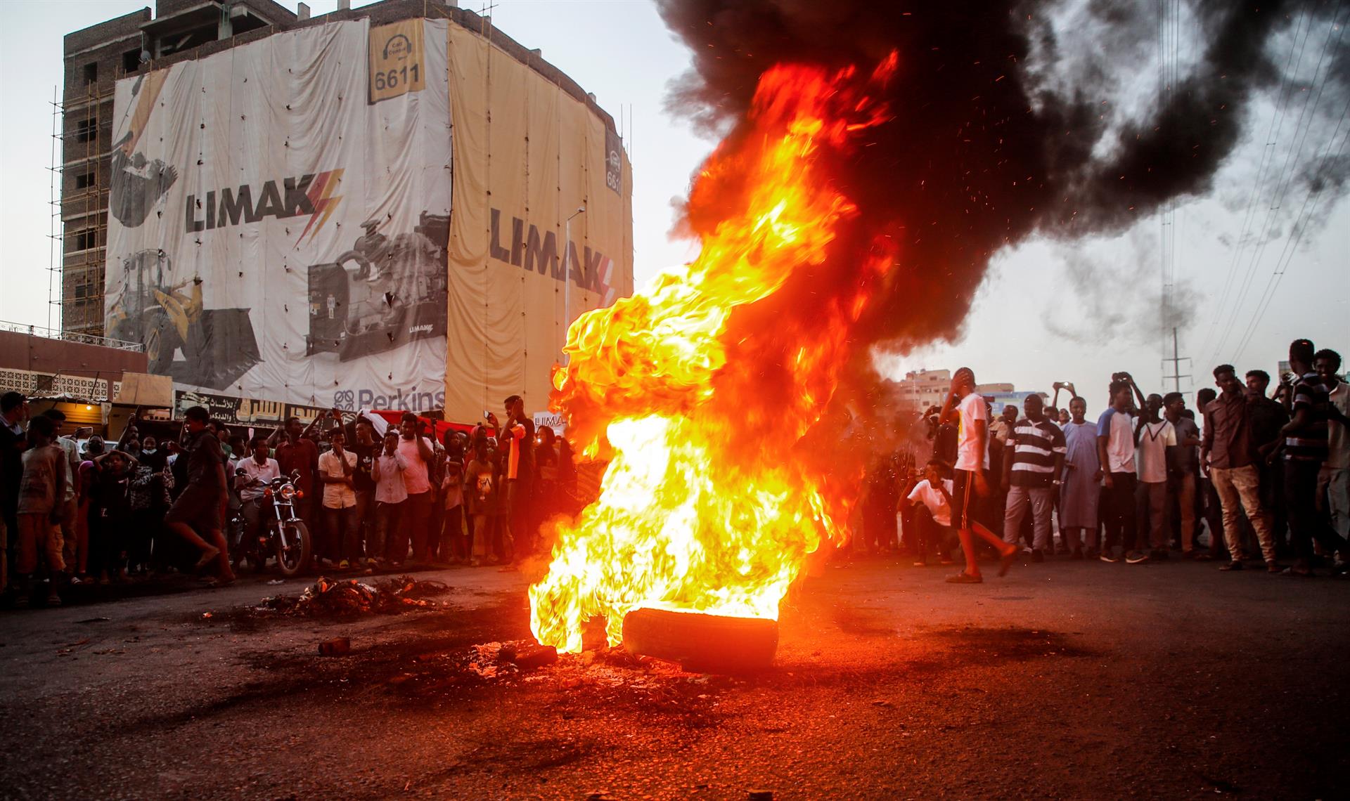 Los manifestantes sudaneses corearon consignas junto a neumáticos en llamas durante una manifestación en la capital, Jartum, Sudán (EFE)