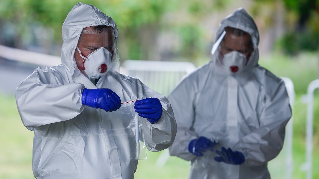 Trajes de protección, máscaras, gafas y guantes mientras realizan pruebas covid (Getty Images)