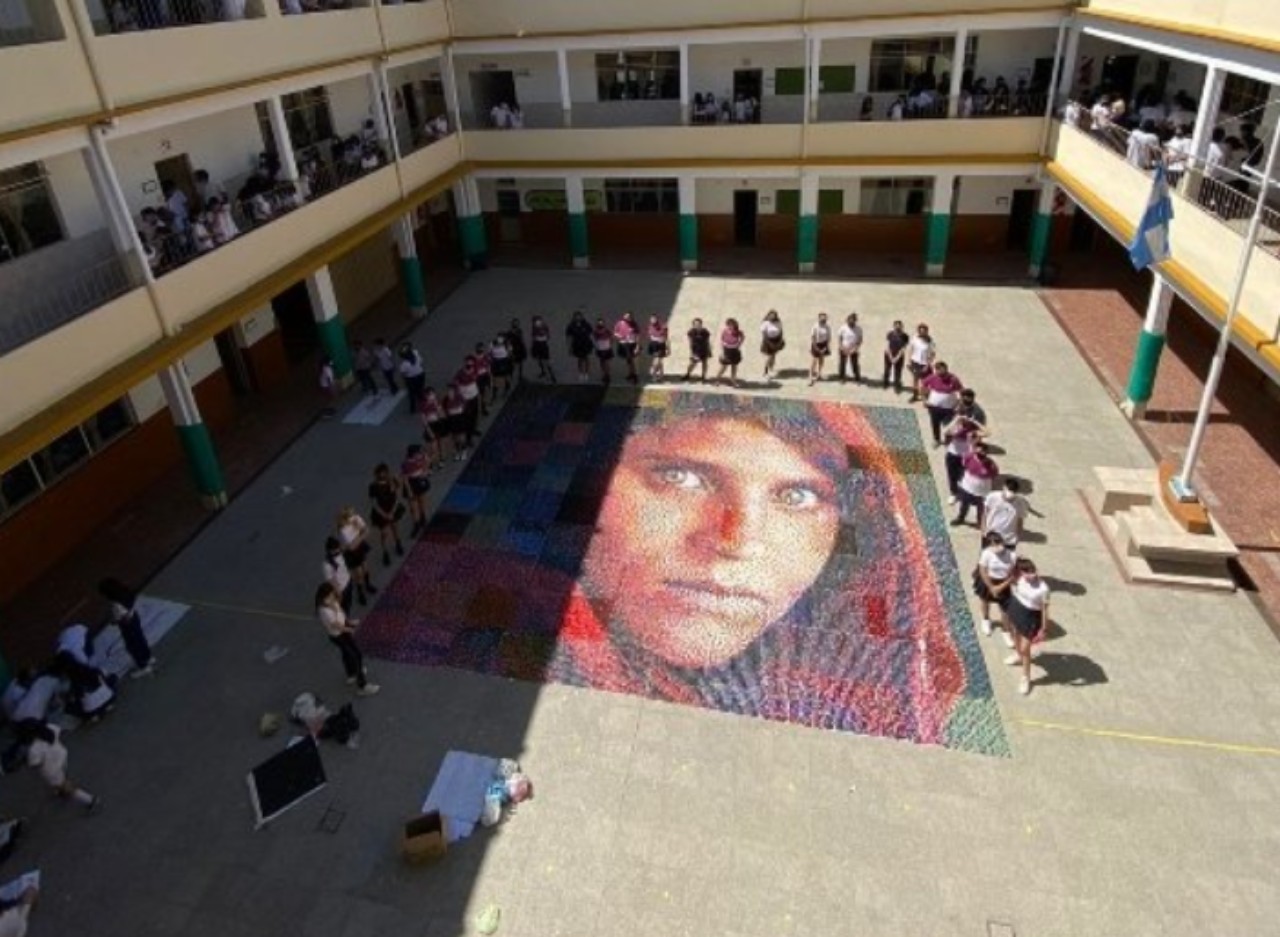 Alumnos recrean retrato de “la niña afgana” con tapitas