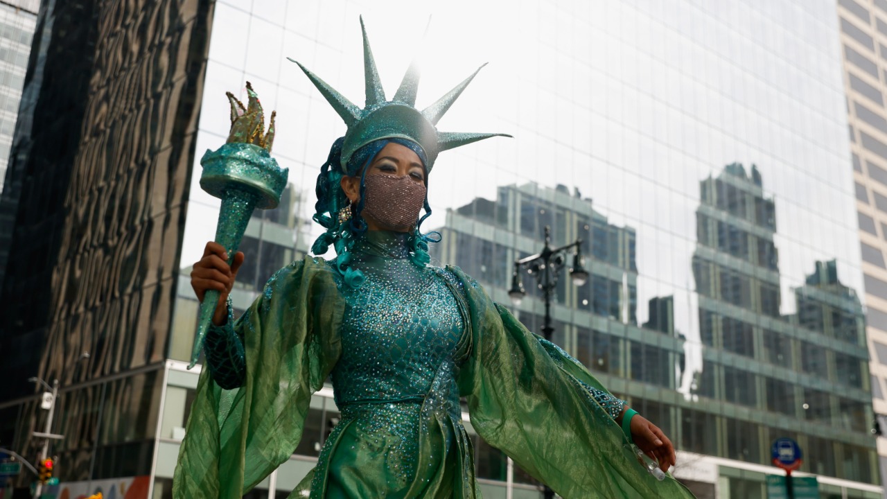 Mujer vestida como la Estatua de la Libertad en desfile del Día de Acción de Gracias 2021