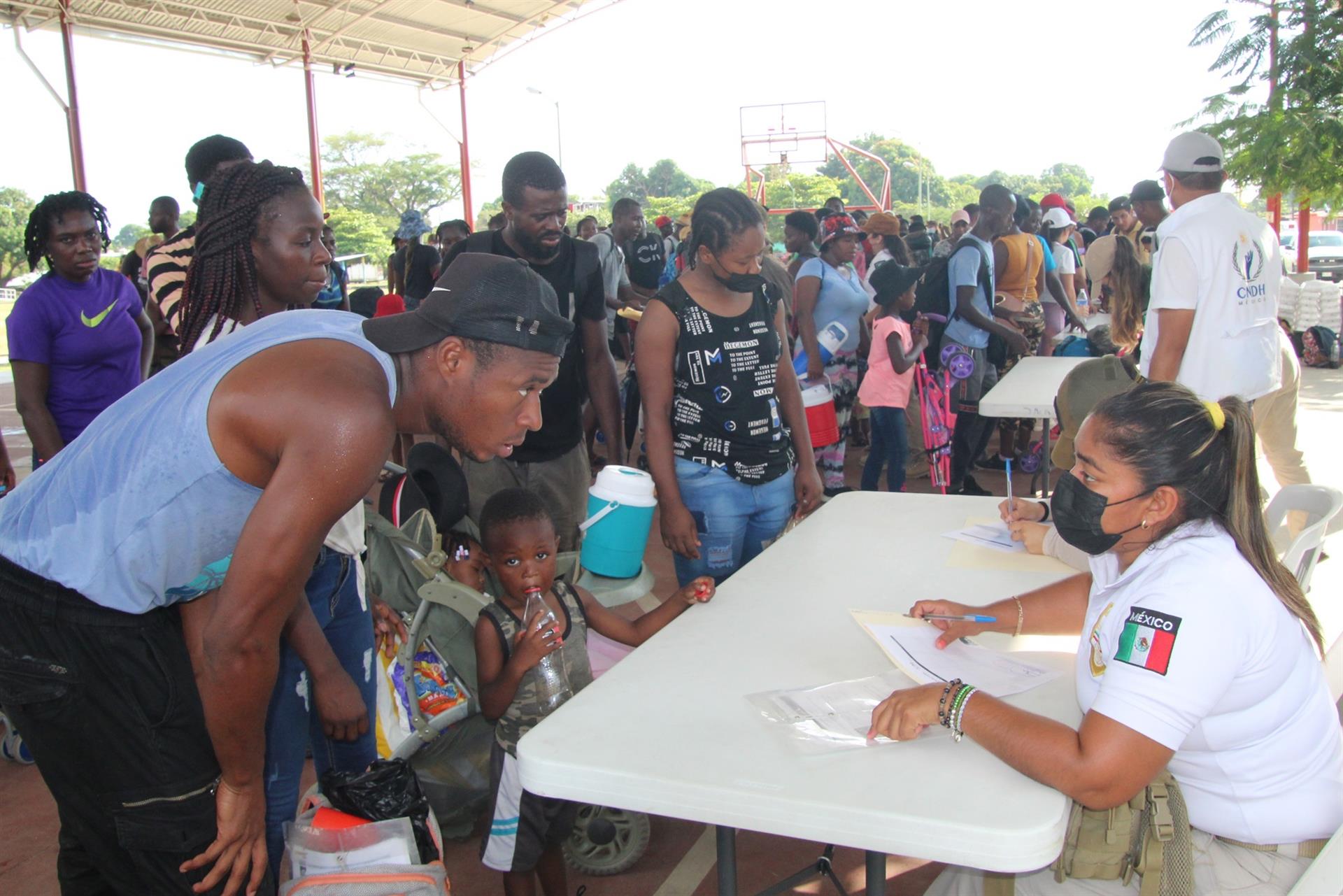 Una familia de migrantes haitianos dan sus datos a personal del Instituto Nacional de Migración (Cuartoscuro)