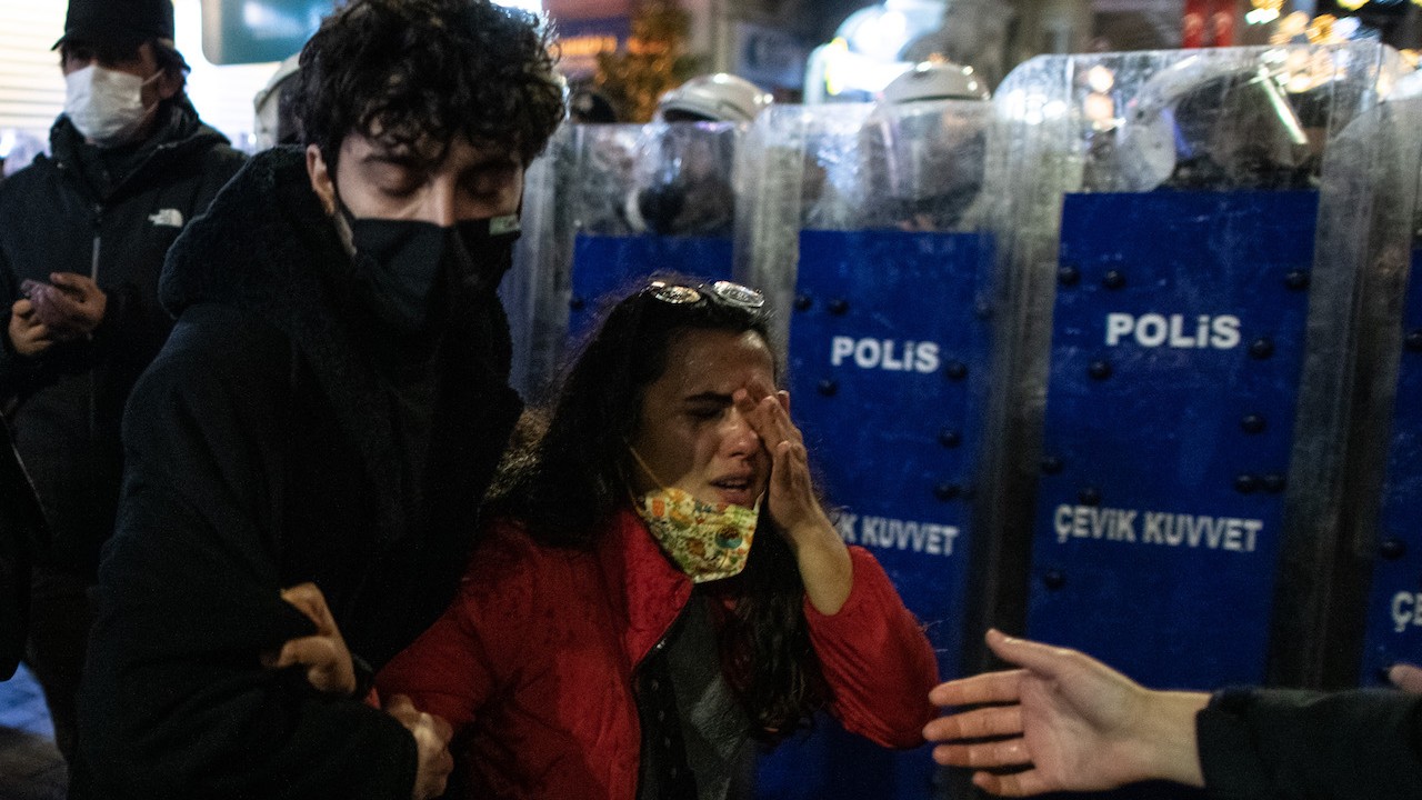 Un hombre ayuda a una mujer afectada por gas lacrimógeno en una manifestación para la Eliminación de la Violencia contra la Mujer en Estambul, Turquía (Getty Images)