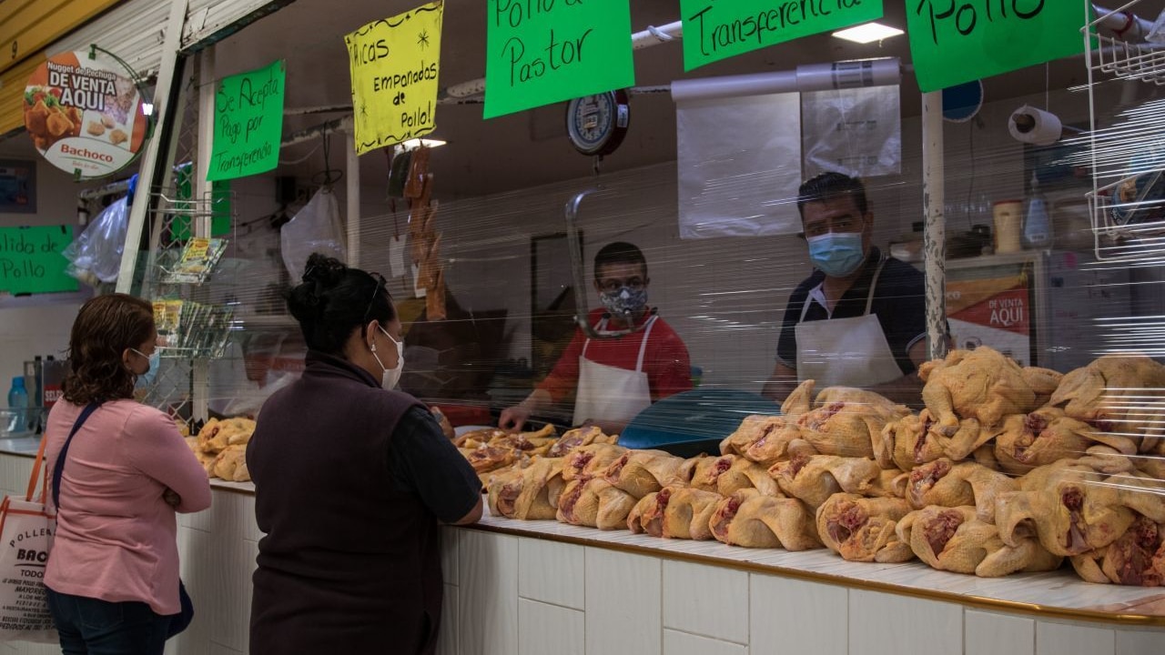 Amas de casa comprando pollo en un mercado mexicano, donde en los últimos días se registró un incremento de precios