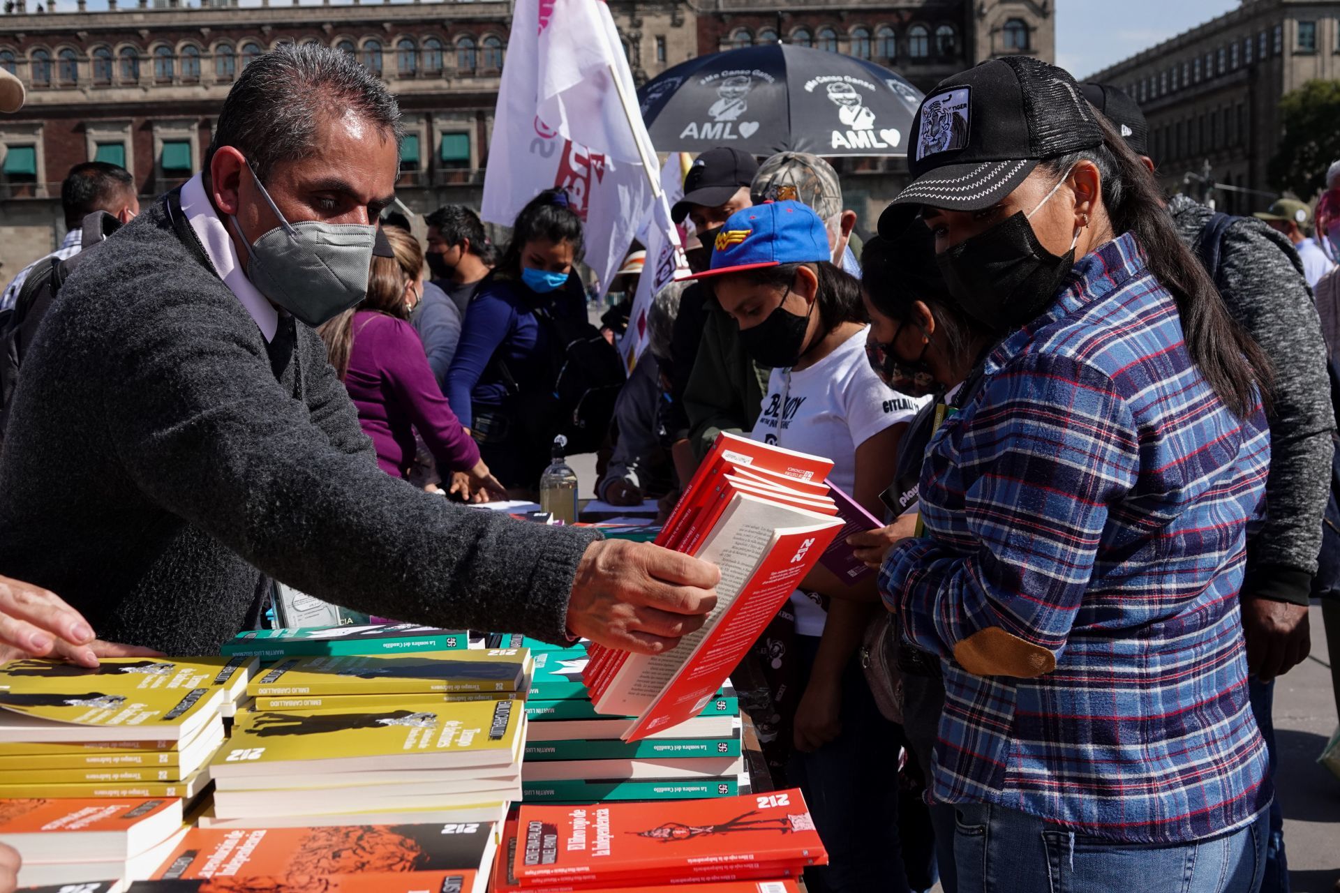 Personal de gobierno regala libros a los asistentes al Zócalo de la CDMX el 1 de diciembre de 2021 (Cuartoscuro)