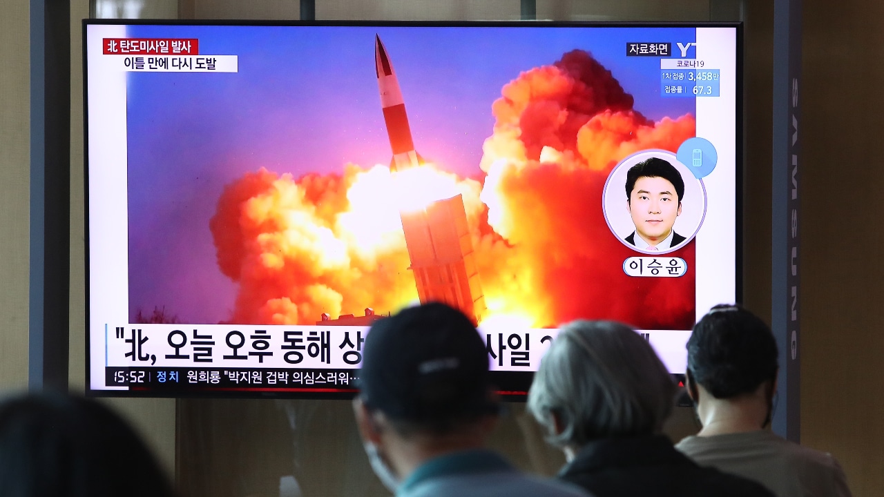 La gente mira un televisor que muestra una imagen del lanzamiento de un misil de Corea del Norte