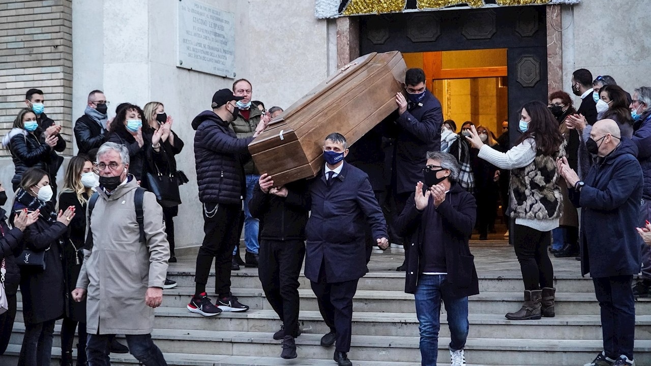 Un grupo de personas carga el ataúd de Hugo Maradona mientras salen de la iglesia de San Vitale, en Nápoles, Italia