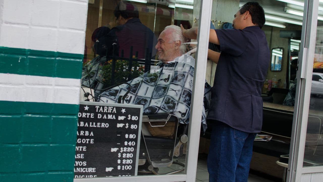 Fotografía de una persona cortándose el cabello en una peluquería en la Ciudad de México