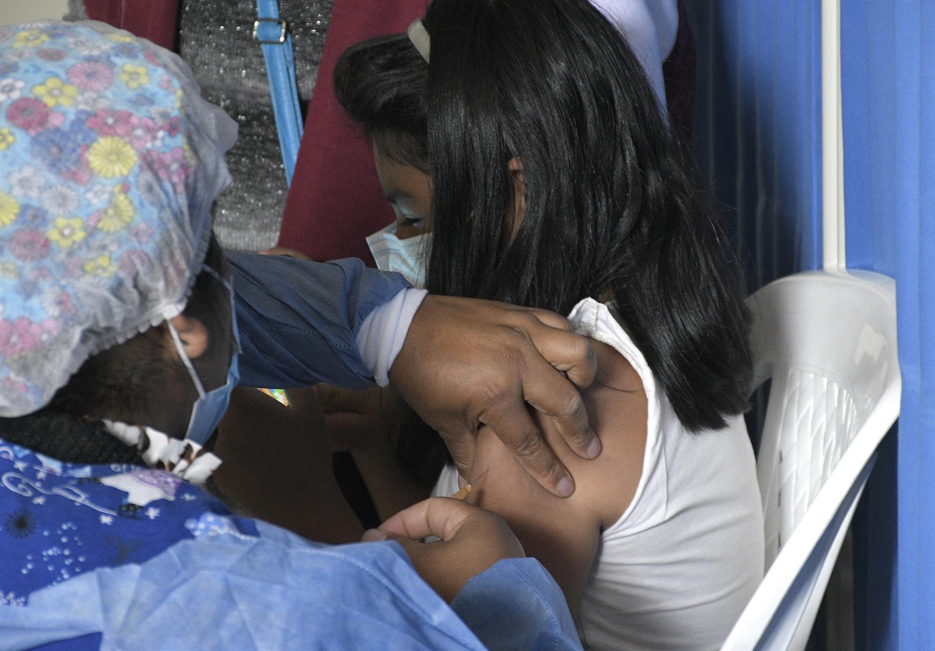 Una enfermera aplica la vacuna contra la COVID-19 a una niña.