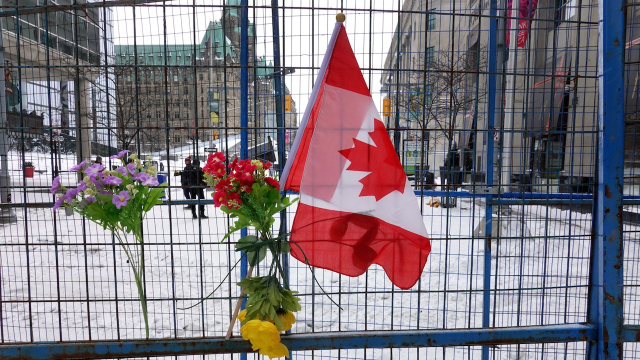 Flores y una bandera cuelgan después que la policía despejara una manifestación de camioneros que se oponían a los mandatos de vacunación covid en Canadá (Getty Images)