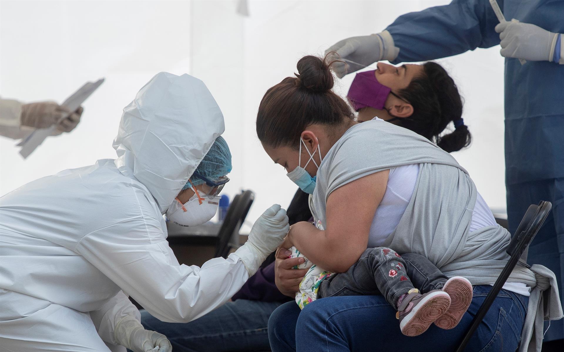 Una señora ayuda a su hija durante una prueba para detectar covid en un hospital del IMSS (EFE)