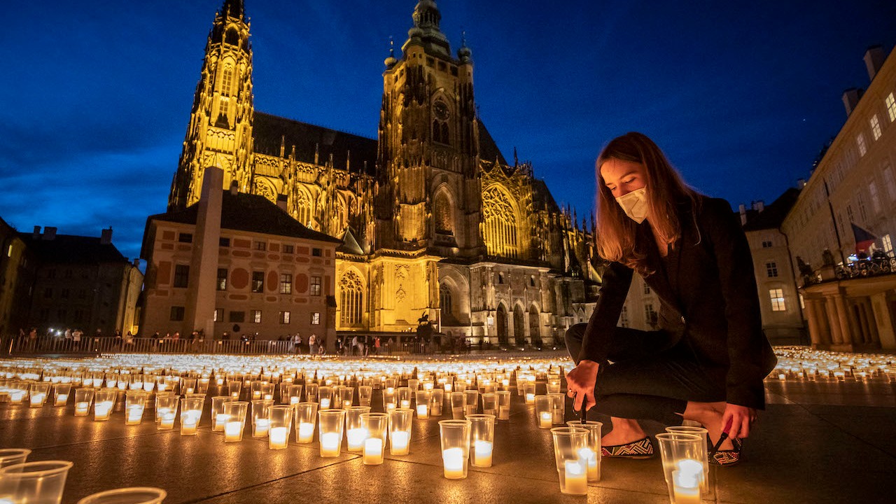 Una mujer enciende una vela para conmemorar a las víctimas de la pandemia de covid en el Castillo de Praga, República Checa (Getty Images)