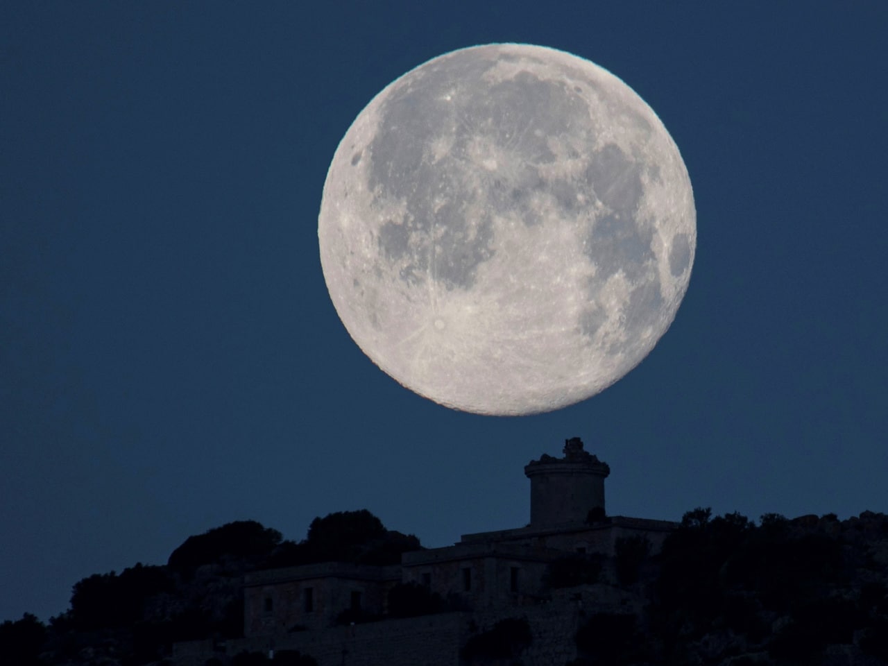 La Luna de Nieve vista tras el faro Far Vell de Sa Dragonera, en Andratx, Mallorca.