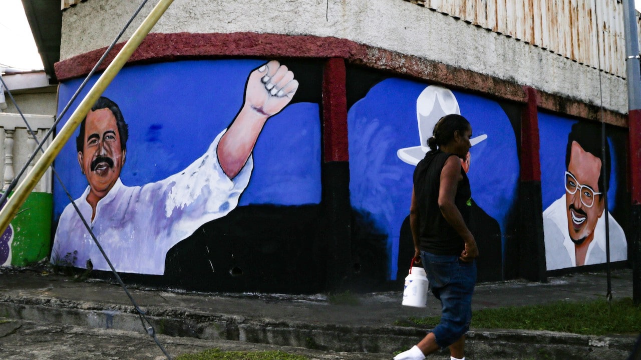 Mujer pasa frente a un mural con la imagen de Daniel Ortega, presidente de Nicaragua (Getty Images)