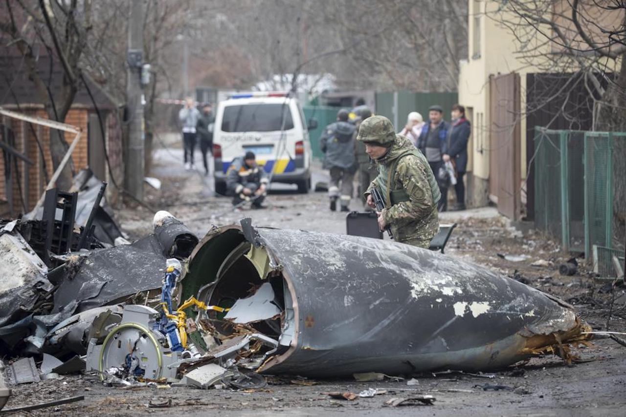 Un soldado ucraniano inspecciono los restos de un avión derribado, en Kiev, 25 de febrero de 2022 (AP)