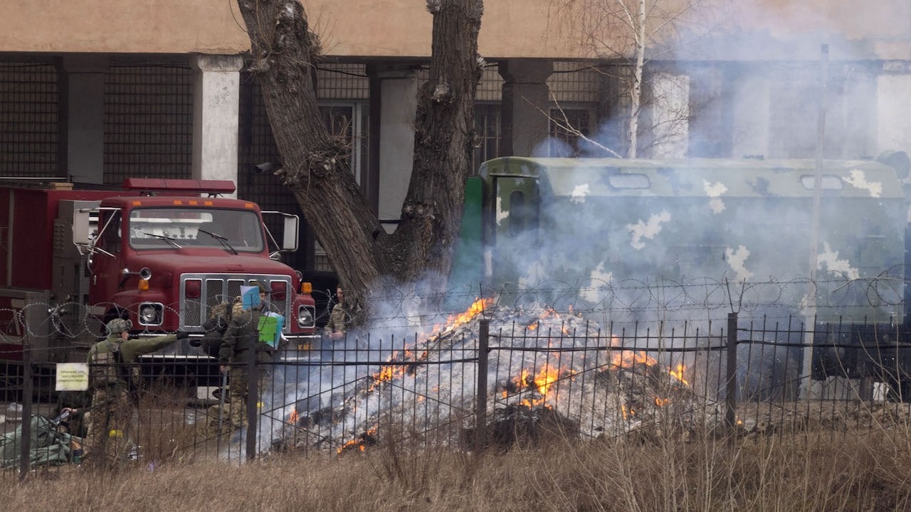 El personal militar arroja objetos al fuego frente a un edificio de inteligencia el 24 de febrero de 2022 en Kiev, Ucrania (Getty Images)