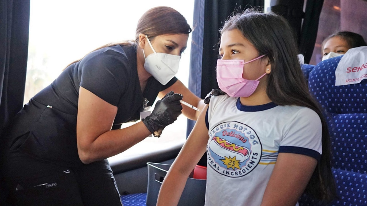 Una niña recibe la vacuna contra la covid de Pfizer en el puente internacional de Laredo, Texas.