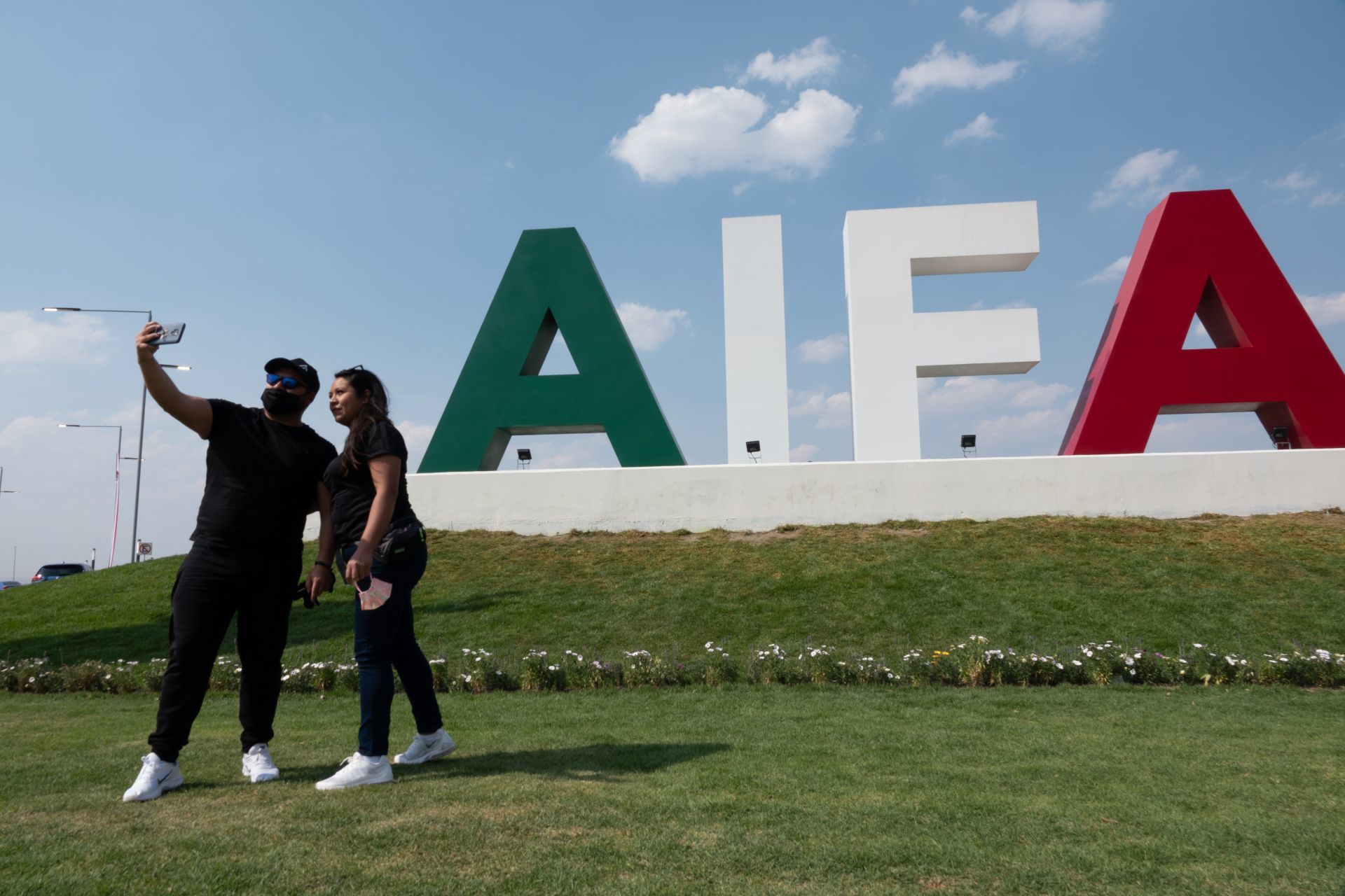 Asistentes se fotografían con la estatua del general Felipe Ángeles a la entrada del Aeropuerto Internacional Felipe Ángeles (AIFA) durante su inauguración