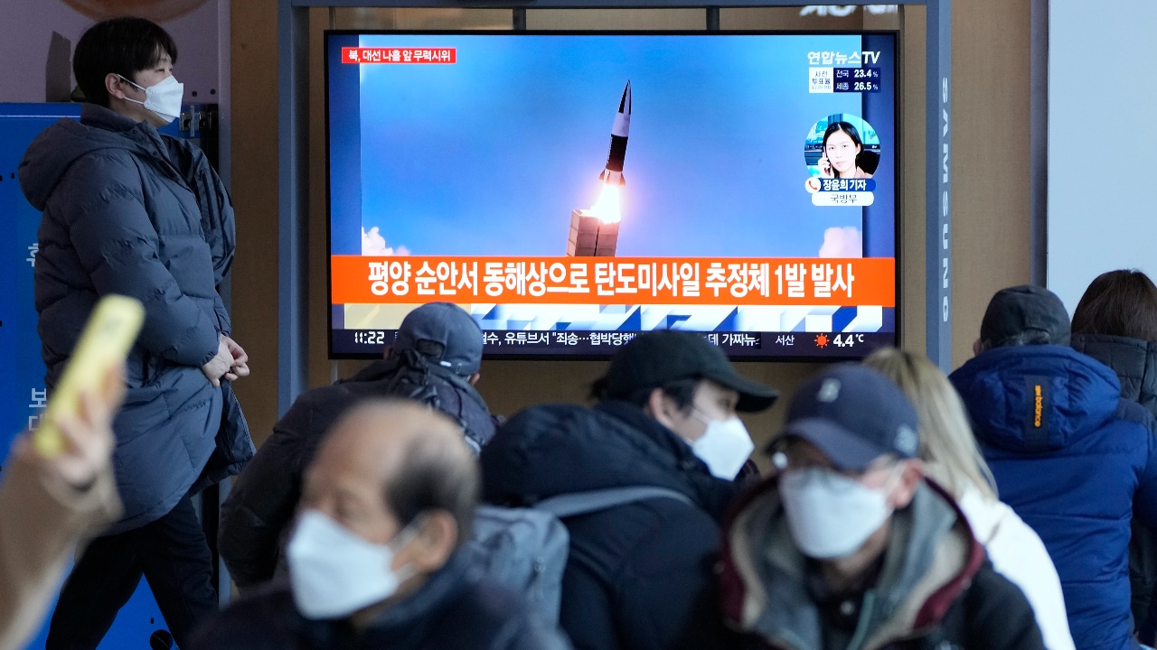 La gente mira un televisor que muestra una imagen de archivo del lanzamiento de un misil de Corea del Norte durante un programa de noticias en Seúl