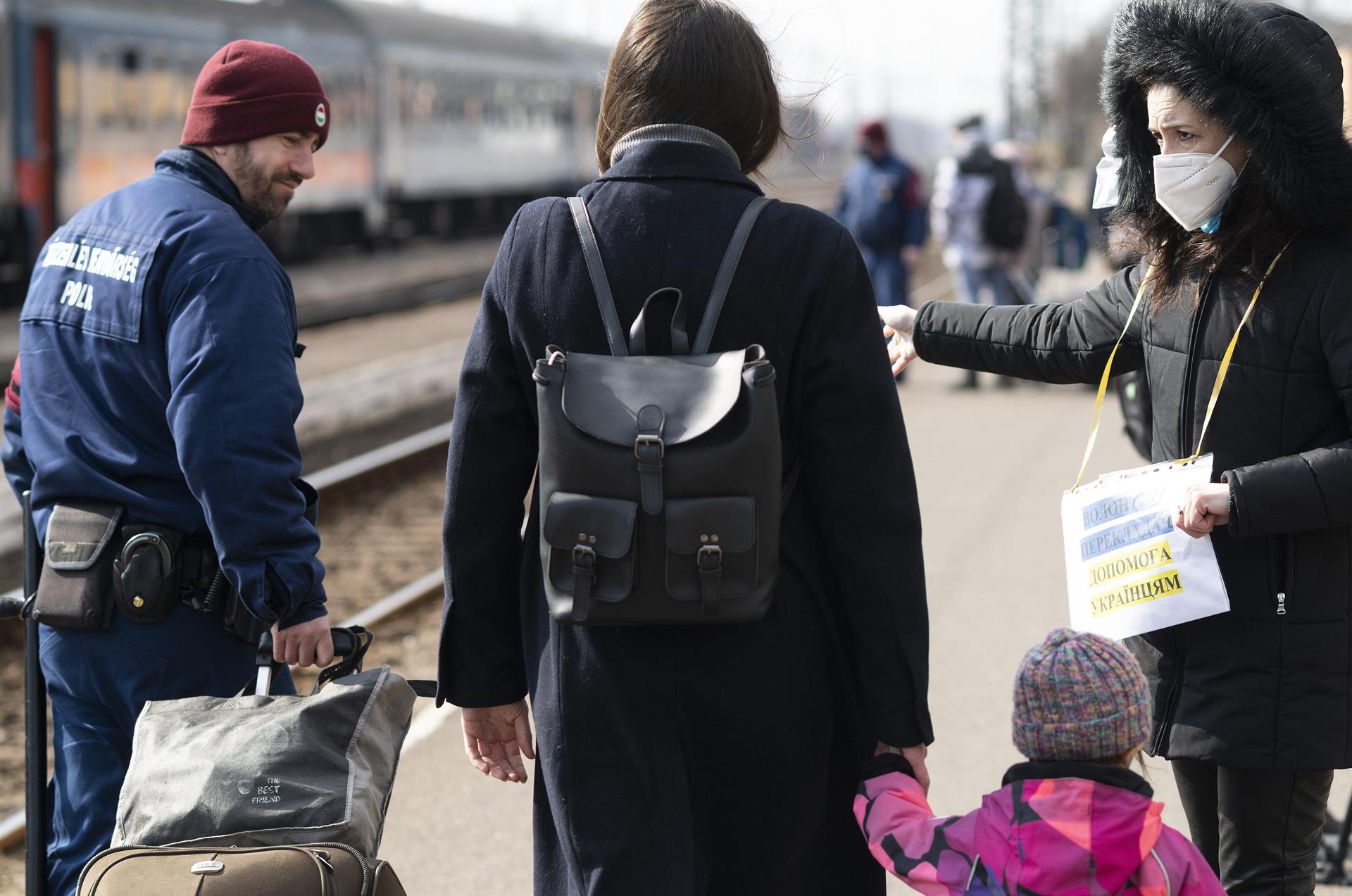 Ayuda a un refugiados de Ucrania que llegan a la estación de tren en Zahony, Hungría, 7 de marzo de 2022 (EFE)