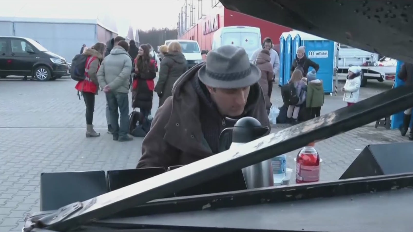video hombre toca el piano mientras refugiados ucranianos cruzan la frontera