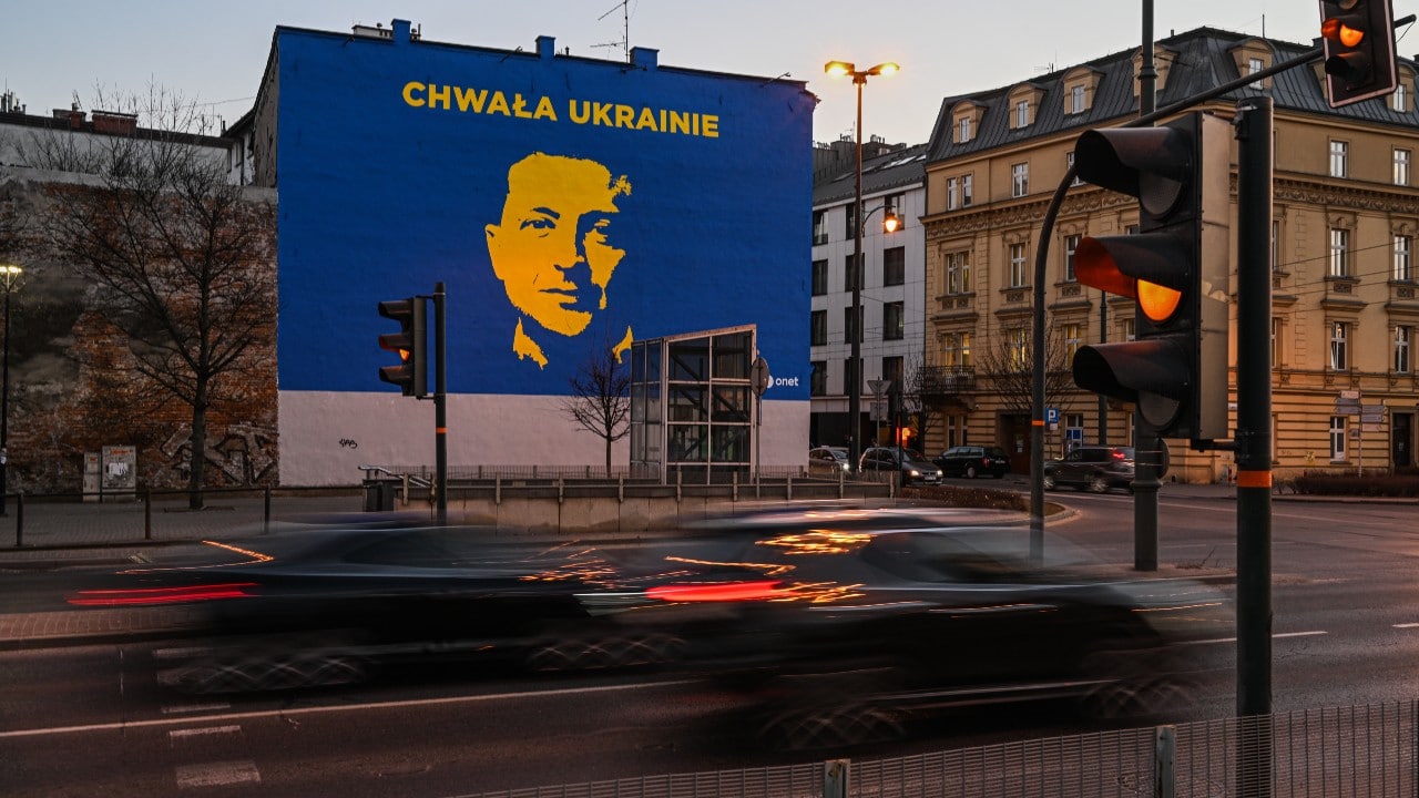 Autos en Polonia pasan frente a un mural pintado recientemente con la imagen del presidente de Ucrania, Volodimir Zelenski (Getty Images)