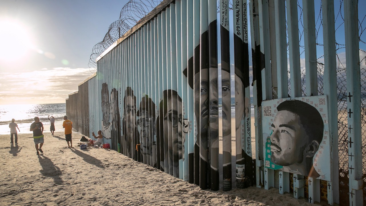 Rostros de personas deportadas de Estados Unidos adornan la valla fronteriza entre Estados Unidos y México, en Tijuana (Getty Images)