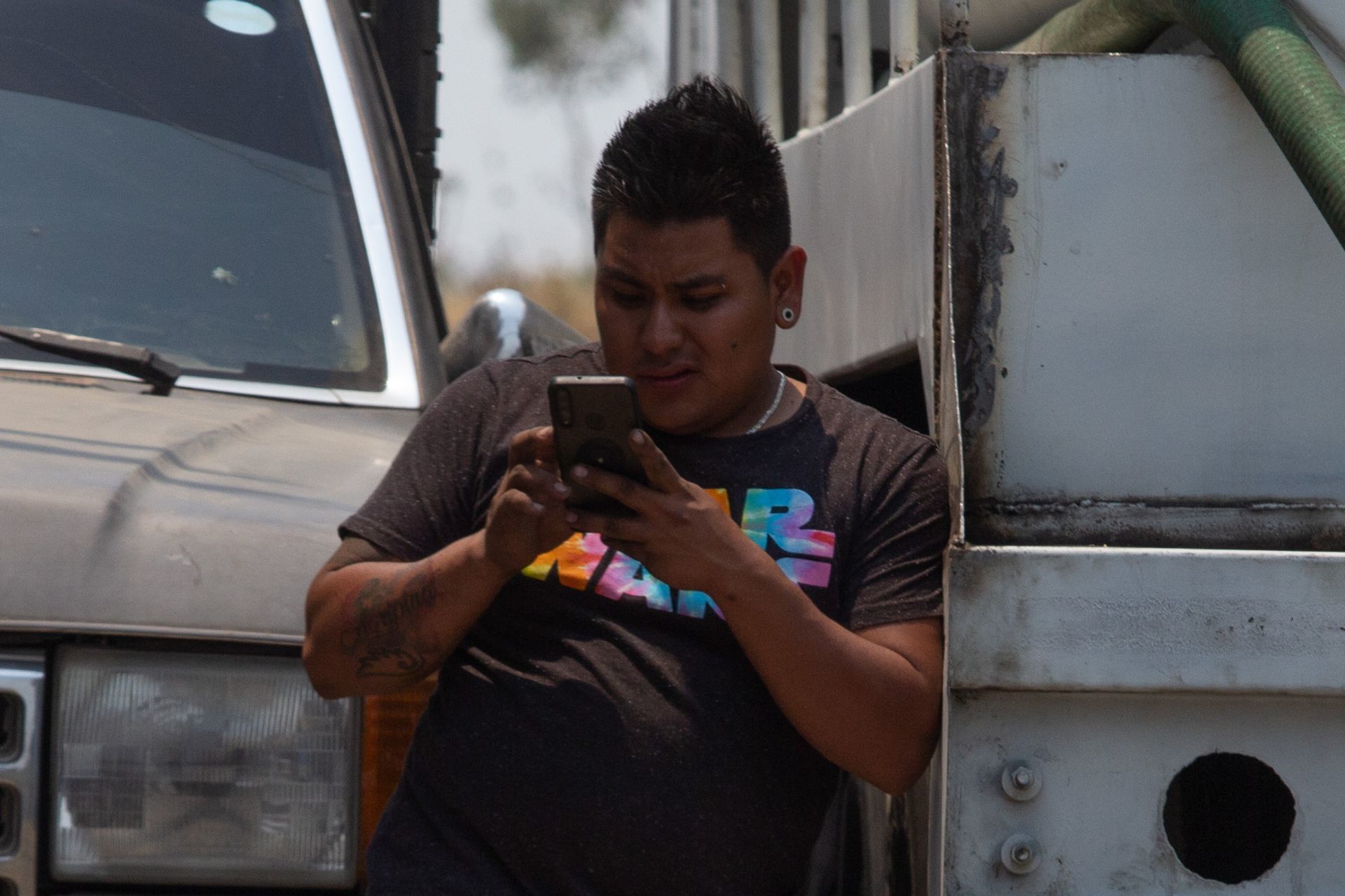 Un joven observa su celular en la alcaldía Iztapalapa (Cuartoscuro)