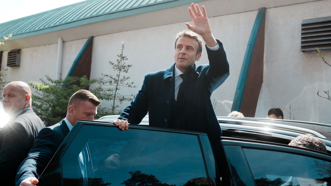 El presidente francés y candidato para la reelección, Emmanuel Macron, saluda a la gente después de votar en la primera vuelta de las elecciones presidenciales.