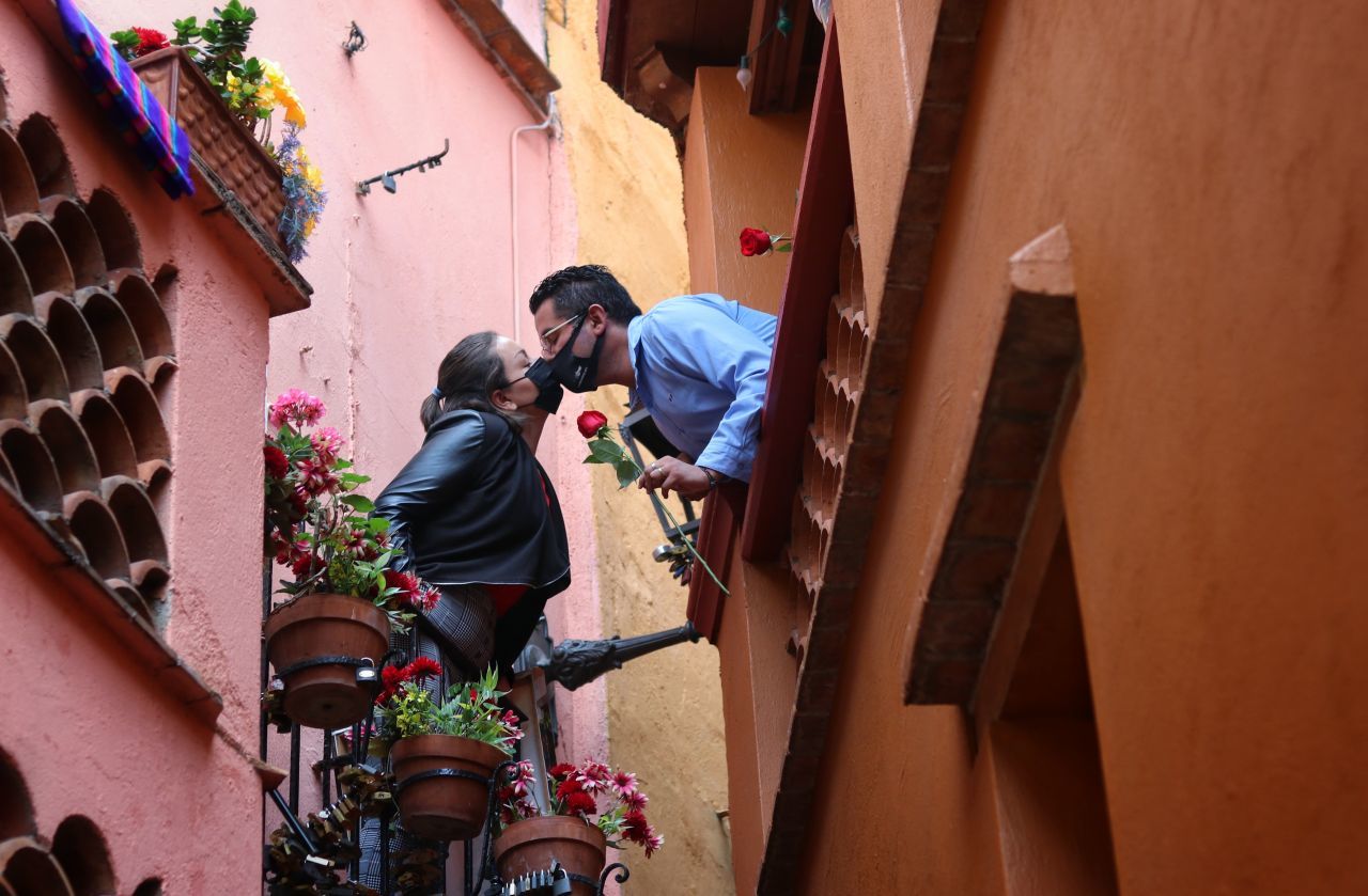 Dos jovenes se besan con un cubrebocas en el famoso y tradicional callejon del beso