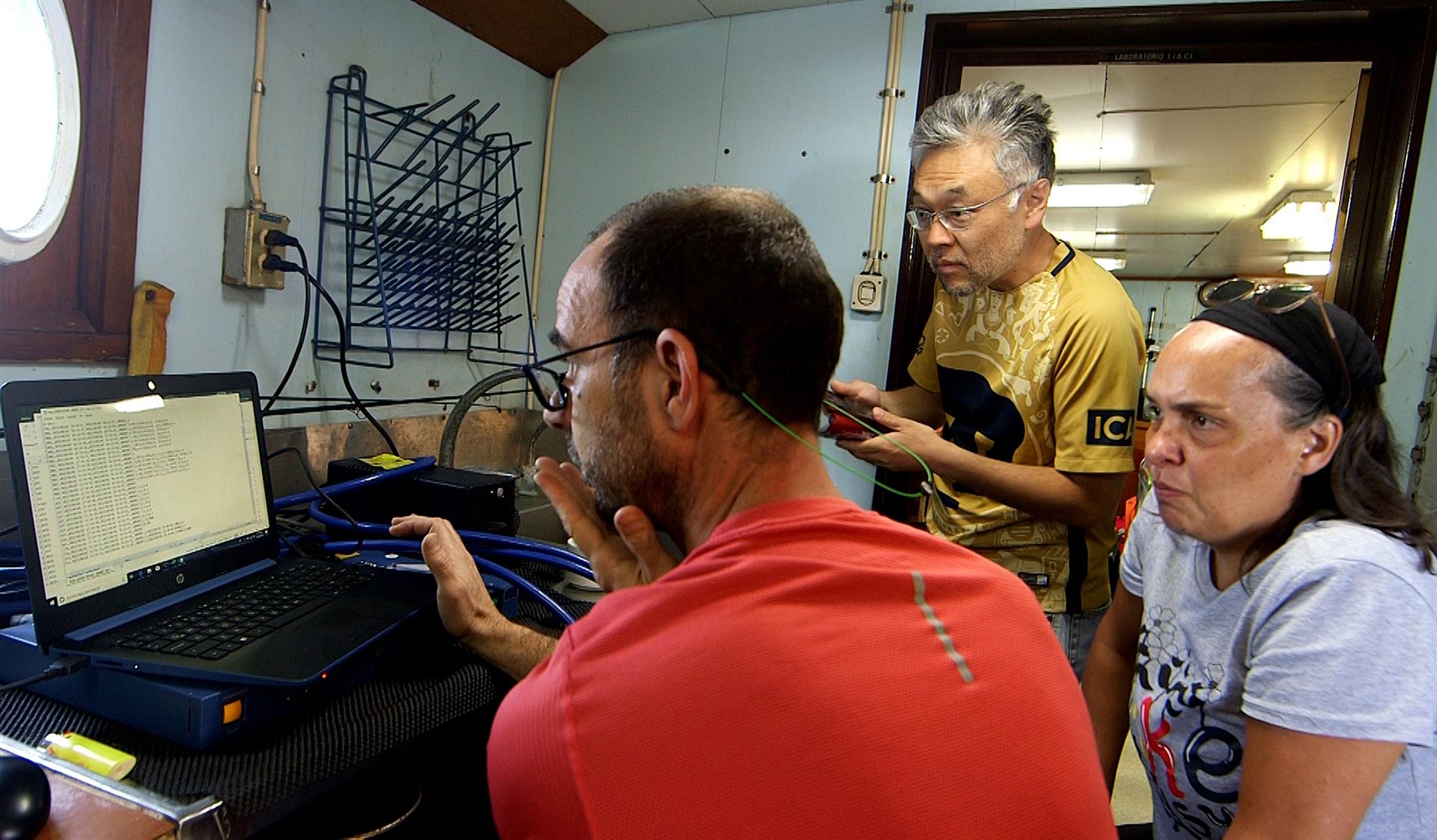 El especialista en física de sismos Víctor Manuel Cruz Atienza (izq.) acompañado de científicos revisan datos a bordo del buque "Puma", el 5 de abril de 2022 en aguas de Mazatlán en Sinaloa (EFE)