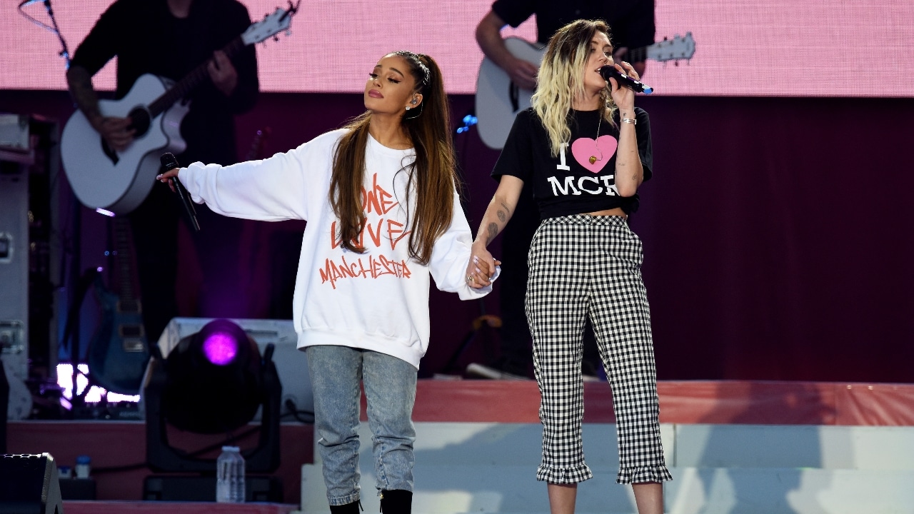 Fotografía de archivo que muestra a Ariana Grande y Miley Cyrus en un escenario en Manchester, Inglaterra.