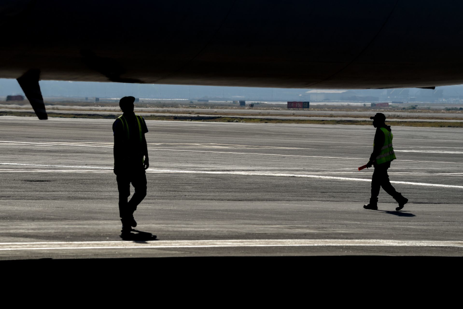 Dos trabajadores caminan sobre la pista de aterrizaje del Aeropuerto Internacional de la Ciudad de México (Cuartoscuro)