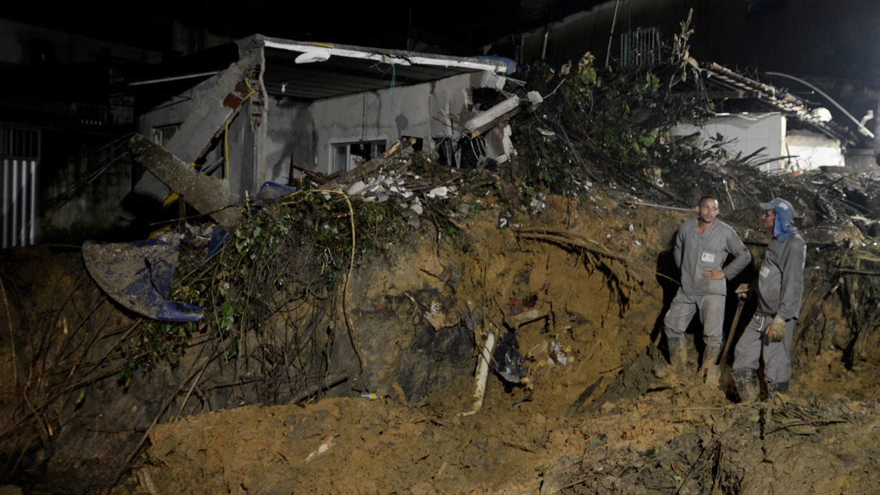 Bomberos y voluntarios trabajan en el área donde ocurrió un deslizamiento de tierra provocado por fuertes lluvias en Brasil