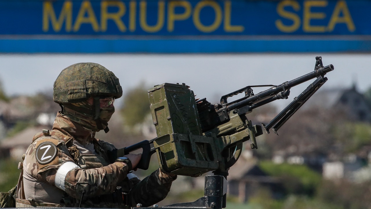 Fotografía que muestra a un militar ruso haciendo guardia en el puerto marítimo de Mariúpol, Ucrania