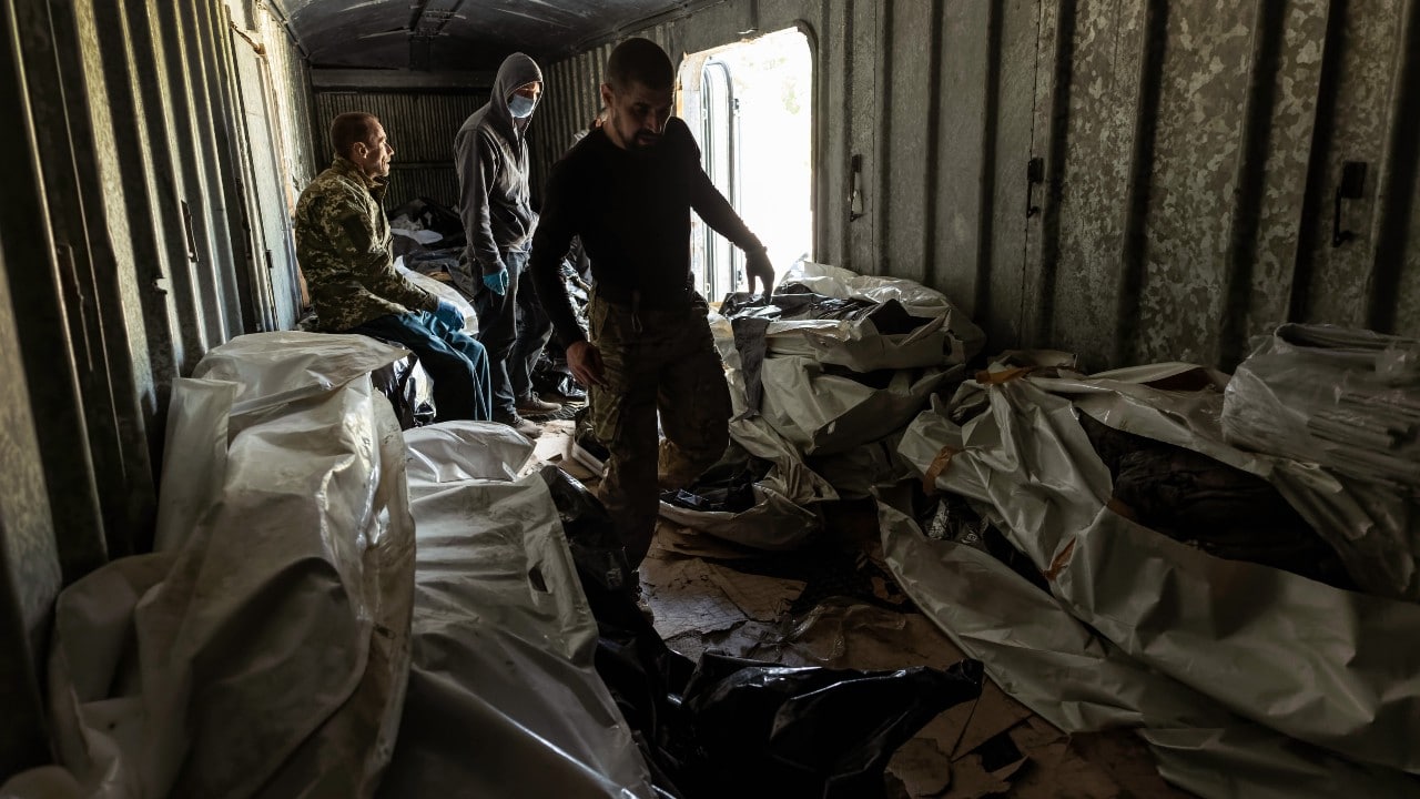 Miembros de un equipo de cooperación civil-militar ucraniano mueven cuerpos de un vagón refrigerado, 24 de mayo de 2022 en Kharkiv, Ucrania (Getty Images)