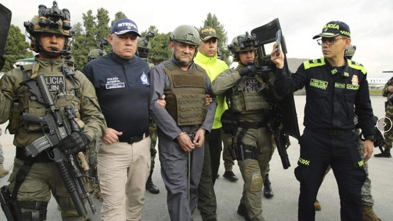 Policías escoltan a Dairo Antonio Úsuga, centro, también conocido como "Otoniel", líder del cártel Clan del Golfo, antes de su extradición a EEUU (Presidencia de Colombia)