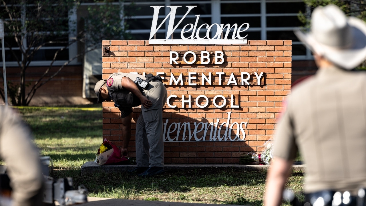 Un policía de Texas deja un ramo de flores para recordar a las víctimas del tiroteo en la escuela primaria Robb, donde 21personas murieron.